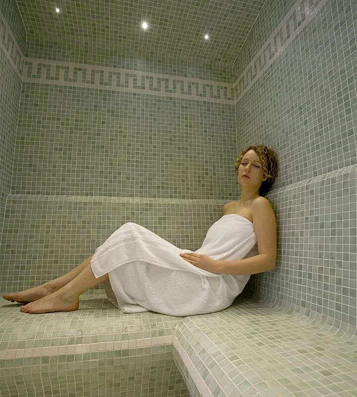 Une personne enveloppée d’une serviette se repose dans le hammam du spa du Château d’Ygrande, en Auvergne.
