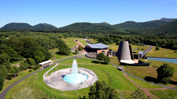 Vue aérienne de Vulcania en Auvergne, avec son bâtiment conique et son bassin à jet d’eau.