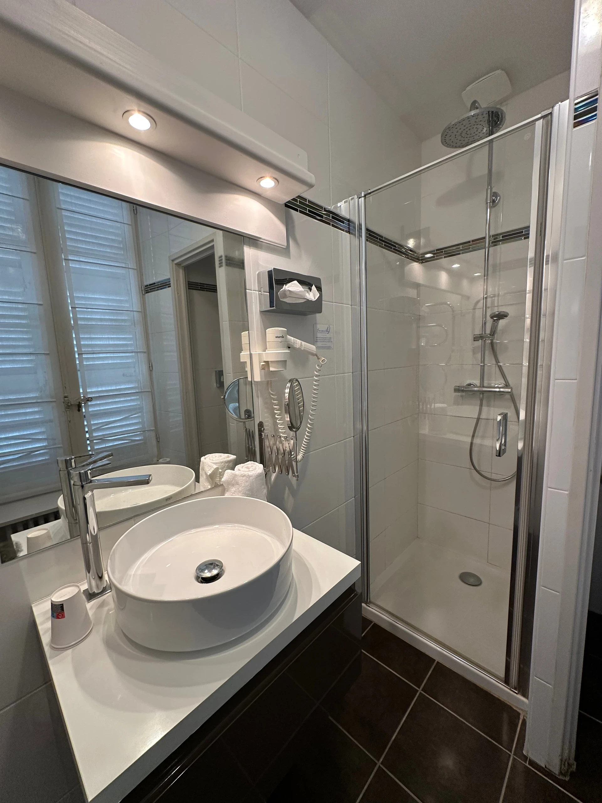 Douche vitrée et vasque ronde dans la salle de bains d’une chambre d’hôtes en Auvergne.