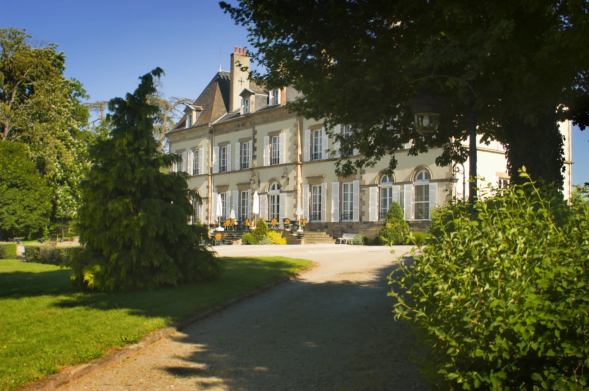 Allée du jardin menant à la façade et à la terrasse des chambres d’hôtes en Auvergne.