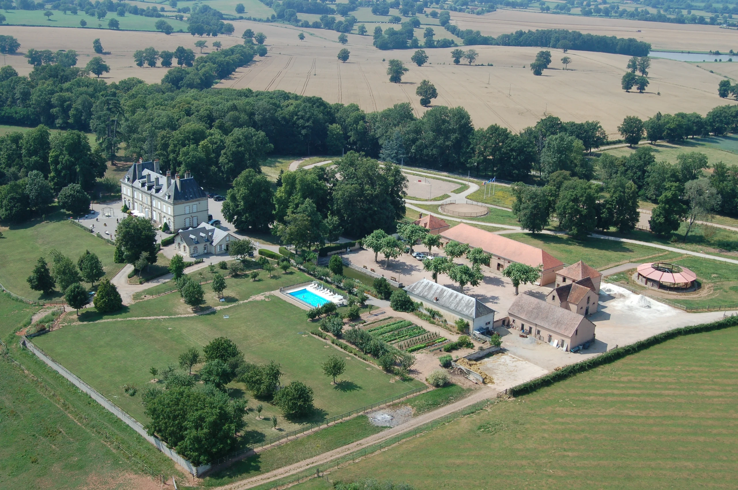 Vue aérienne du domaine des chambres d’hôtes du Château d’Ygrande en Auvergne, avec parc, piscine et dépendances.